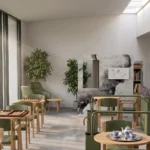Sala pranzo comune luminosa con tavoli, sedute e fioriere divisorie Agora affacciata sul giardino
