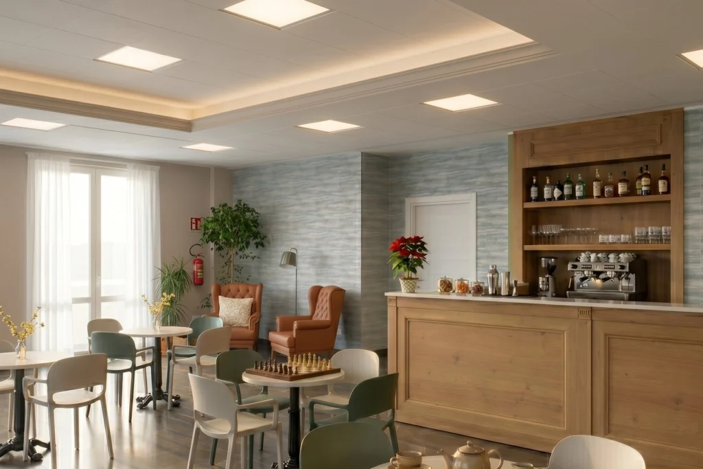 Caffetteria interna con bancone in legno, tavolini e poltrone in pelle — RSA, progetto Danielato