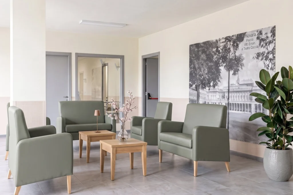 Sala d'attesa con poltrone in ecopelle e tavolini in legno — RSA, progetto Novara