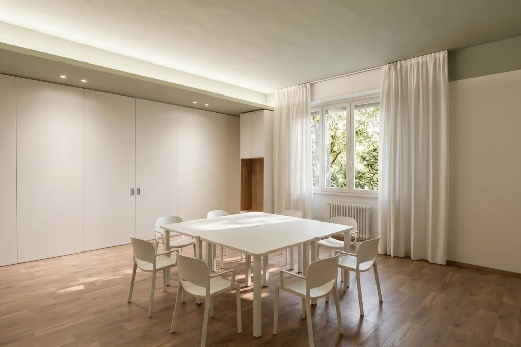 Sala riunioni con armadiature a filo muro e tavolo quadrato — RSA, progetto PCDR