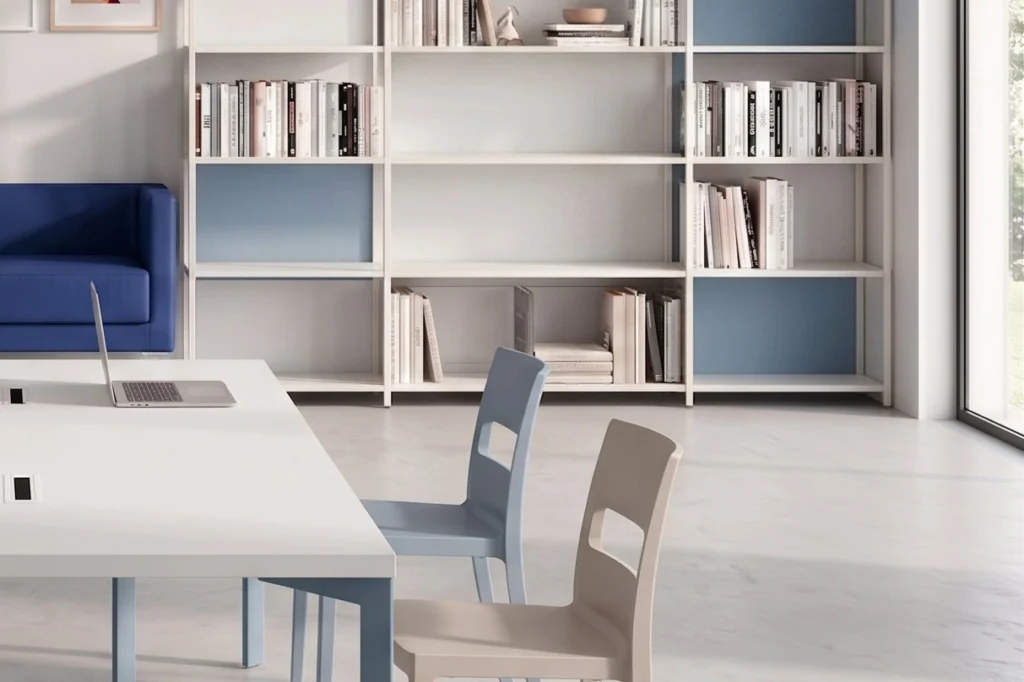 Area studio con libreria modulare a giorno e tavolo lungo — residenza universitaria, progetto Studentati